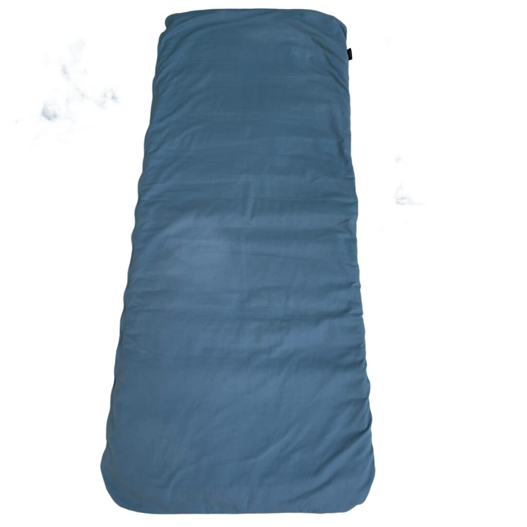 Full-length wool sleeping pad in a slate-blue organic cotton cover, tapered towards the foot, photographed flat from above